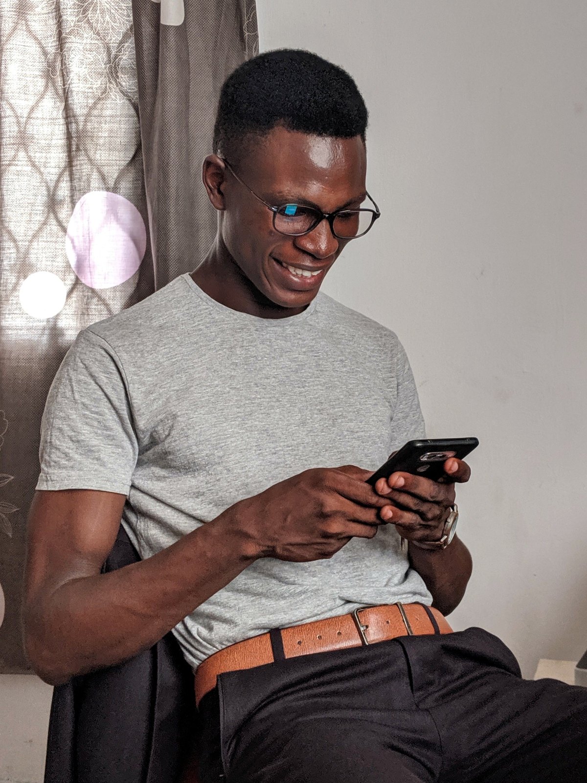 A person seated and using a smartphone